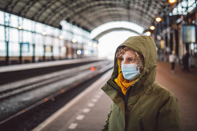 Woman wearing mask standing on platform