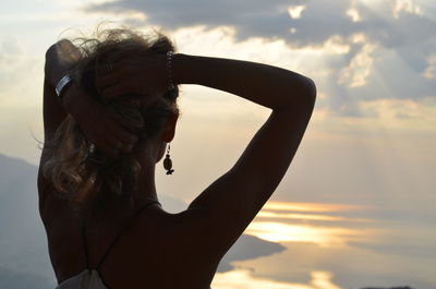 Portrait of woman in sea against sky during sunset