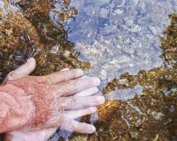 Cropped image of man washing hands in shallow water