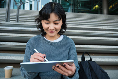 Portrait of young woman using mobile phone