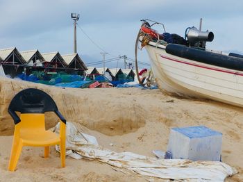 Deck chairs on beach against sky