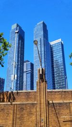 Low angle view of modern buildings against clear blue sky