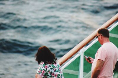 Rear view of people on boat in sea