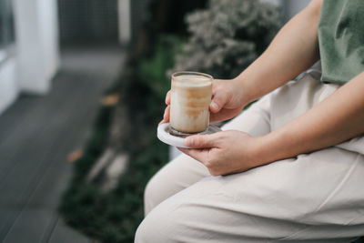 Midsection of man holding coffee cup