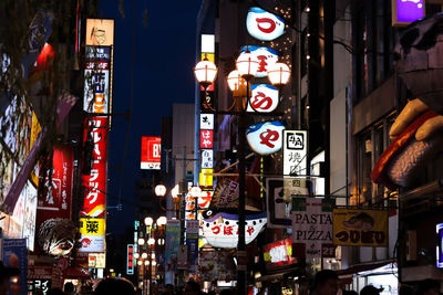 Illuminated street amidst buildings in city at night