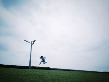 Low angle view of boy jumping on landscape