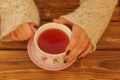 Midsection of woman holding coffee cup