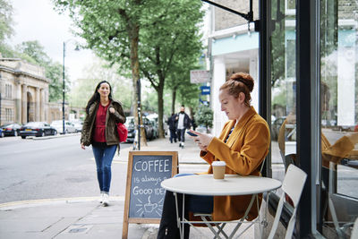 Young woman sitting on table at cafe