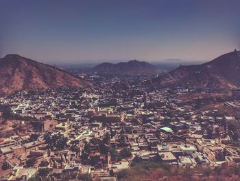 Aerial view of town and mountains against clear sky