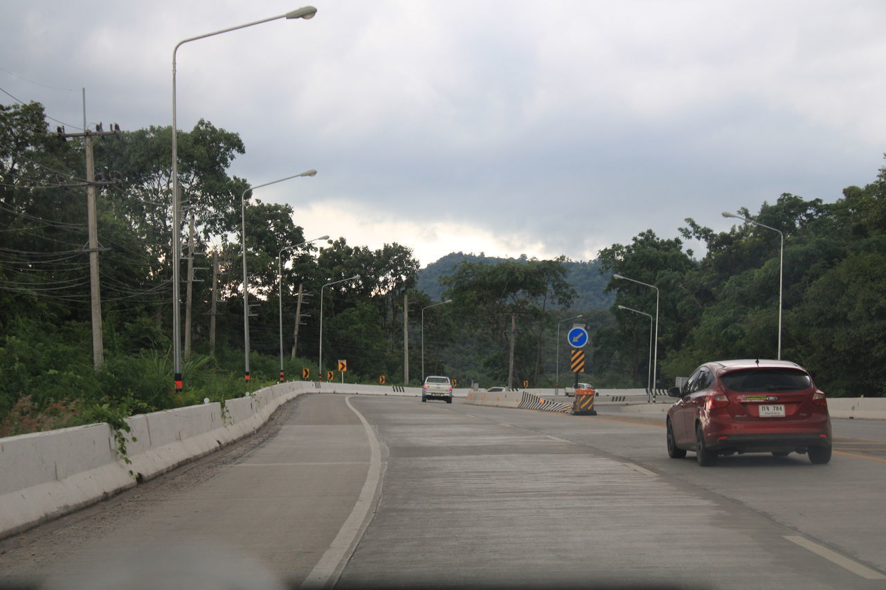 VEHICLES ON ROAD AGAINST SKY