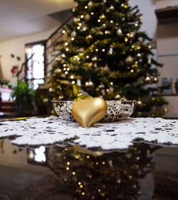 Close-up of illuminated christmas tree on table at home