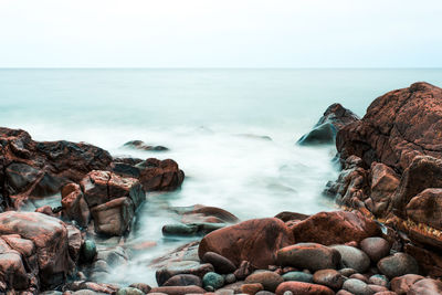 Scenic view of rocks in sea against sky