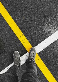 Low section of person standing on road