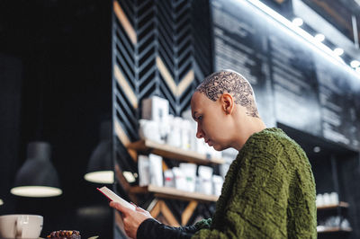 Side view of young man using mobile phone