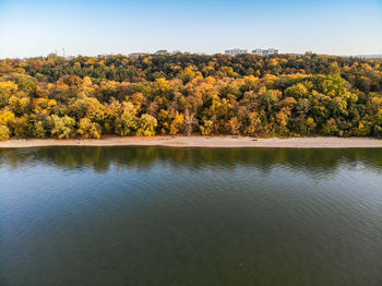 Scenic view of lake by trees against sky