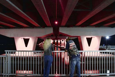 Rear view of people standing on bridge