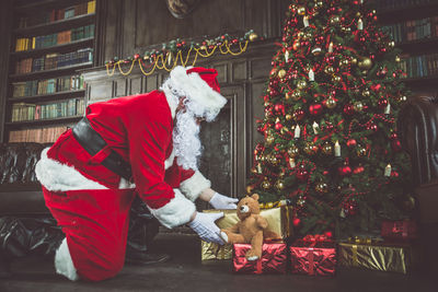 Midsection of man with dog on christmas tree