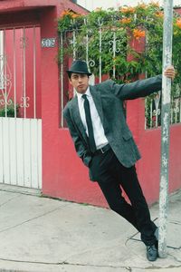 Portrait of young man standing against wall