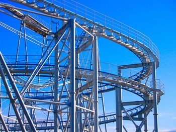 Low angle view of ferris wheel against blue sky