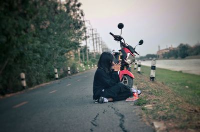 Side view of couple sitting on road