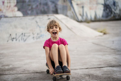 Full length of girl skateboarding at park