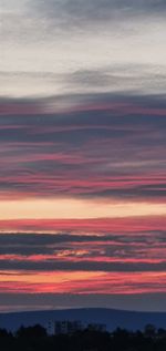 Scenic view of dramatic sky over silhouette landscape