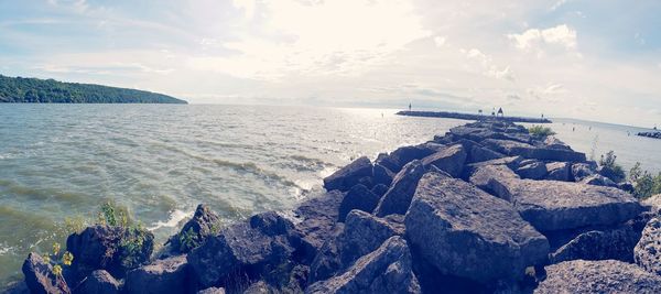 Rocks by sea against sky