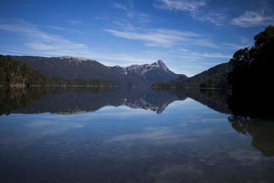 Scenic view of lake and mountains against blue sky