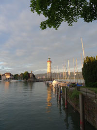 Bridge over river by buildings against sky in city