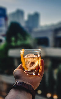 Hand holding a cocktail at sunset