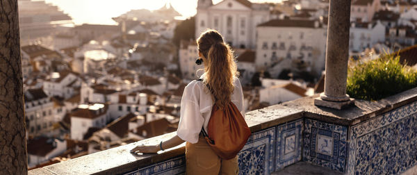 Woman standing by building in city