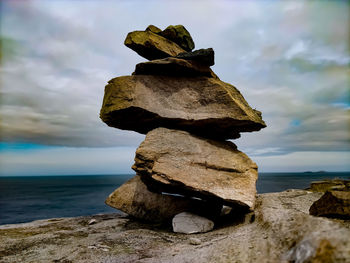 Stack of rocks on beach against sky