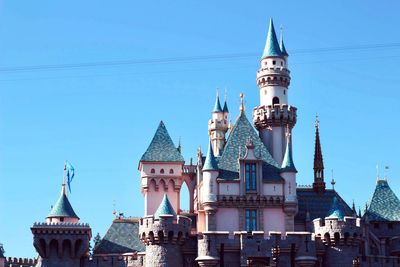 View of buildings in city against clear blue sky