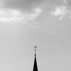 Weather vane on high section against sky