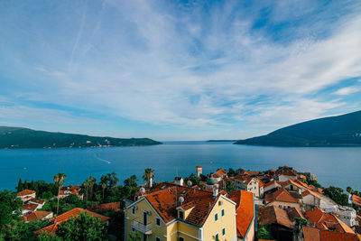 High angle view of townscape by sea against sky