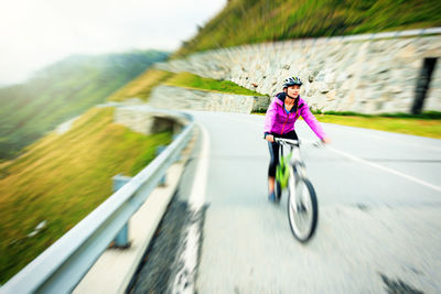Person with bicycle on road against sky