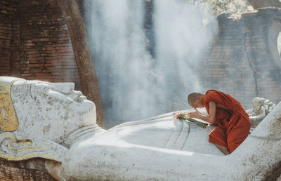 Side view of senior man sitting at temple