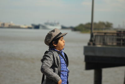 Side view of boy gesturing while standing at beach