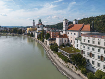 Germany, bavaria, passau, aerial view of innkai promenade in summer with st. stephens cathedral and st. michaels church in background