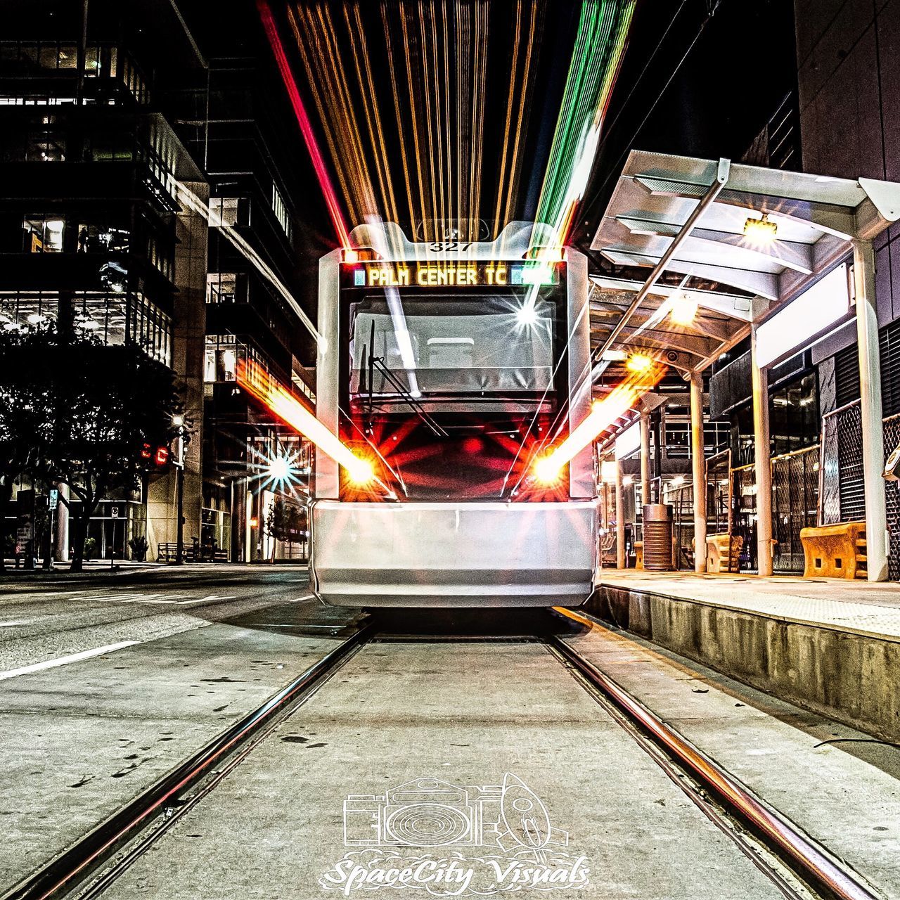 LIGHT TRAILS ON ILLUMINATED STREET AT NIGHT