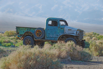 Abandoned car on field in a ghost town