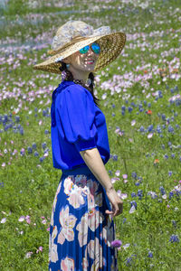 Full length of woman wearing hat standing on field