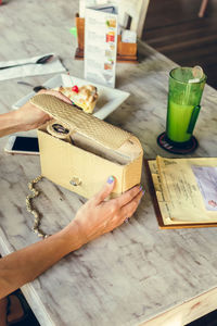 High angle view of hand holding book on table