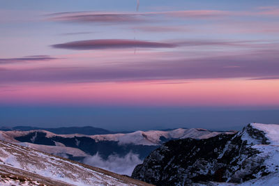 Scenic view of snowcapped mountains against sky during sunset