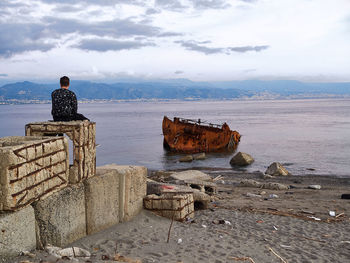Rear view of people looking at sea against sky