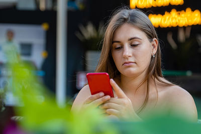 Young woman using phone outdoors