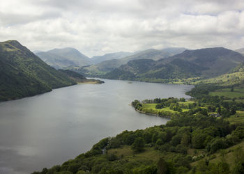 Scenic view of lake and mountains against cloudy sky