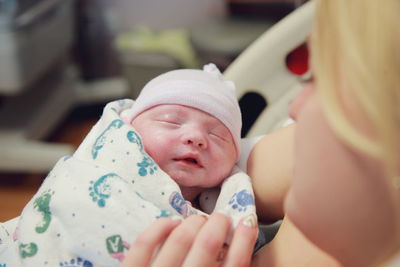 Newborn held by mother