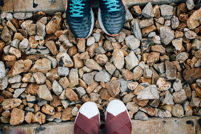 Directly above shot of footwear on stones