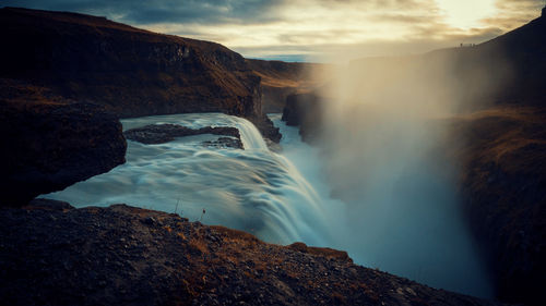 Scenic view of waterfall against sky